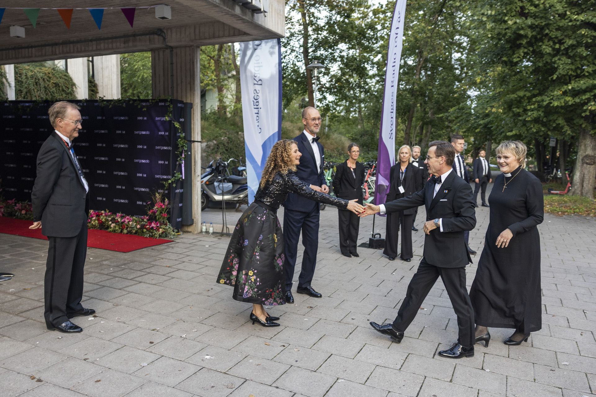 Statsminister Ulf Kristersson (M) med frun Birgitta Ed välkomnas av SR:s VD Cilla Benkö och SR:s styrelseordförande Johan Sidenmark.